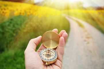 Compass in the hand against rural road