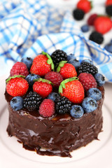 Tasty chocolate cake with different berries, on plate