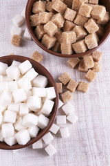 Brown and white refined sugar in color bowls