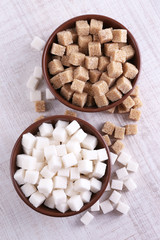 Brown and white refined sugar in color bowls