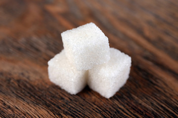 Fototapeta na wymiar White refined sugar on wooden background