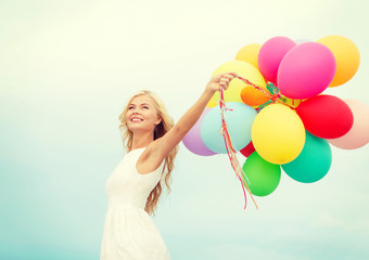 Fototapeta na wymiar smiling woman with colorful balloons outside