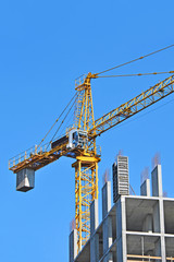 Crane and building construction site against blue sky