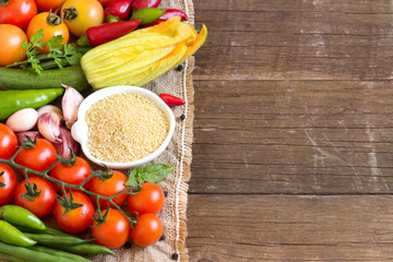Raw Organic millet in bowl and vegetables