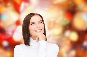 thinking and smiling woman in white sweater