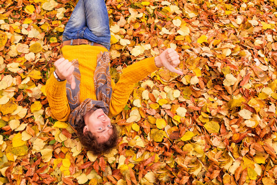 curly man in sweater and scarf showing tumbs up