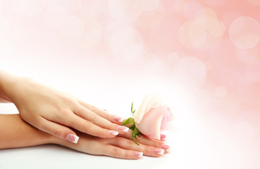 Young woman hands with elegance manicure on bright background