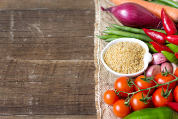 Raw Organic bulgur in bowl and vegetables