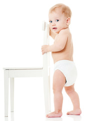 happy baby  playing with white chair