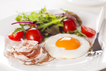 Breakfast with eggs, ham and fresh salad.