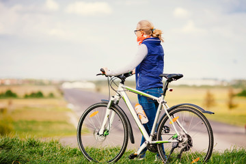 Fototapeta premium Girl with bike on hill
