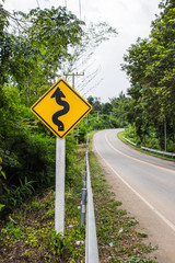 Curvy road sign to the mountain in rural area