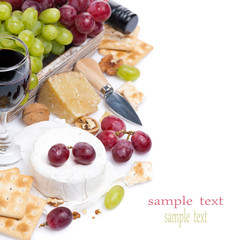cheeses, red and green grapes, crackers and wine, isolated