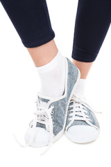 Female legs in sneakers isolated on white