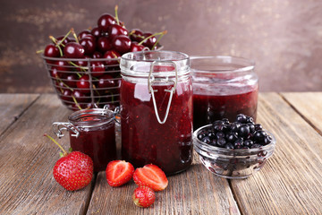 Berries jam in glass jar on table, close-up