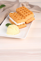 Tasty belgian waffles with ice cream on wooden table