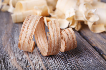 Wood shavings on grey wooden background closeup