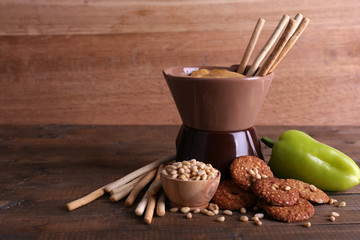 Fondue, spice, biscuits and pepper on wooden background