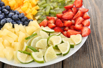 Sliced fruits on plate on wooden table