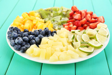 Sliced fruits on plate on wooden table