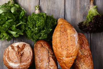 Fresh baked bread and fresh herbs, on wooden background