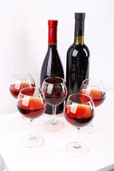 Glasses and wine bottle on table in room