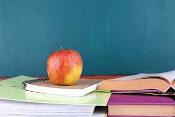 School supplies on table on blackboard background