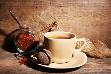 Cup of tasty rooibos tea, on wooden table