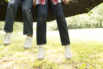 children's legs relaxing on tree