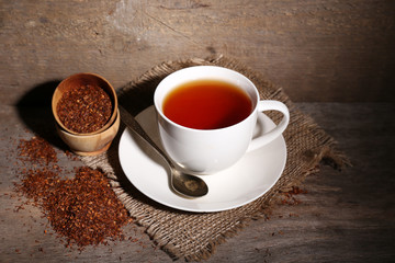 Obraz na płótnie Canvas Cup of tasty rooibos tea, on wooden table