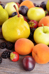 Naklejka na ściany i meble Ripe fruits and berries on wooden background