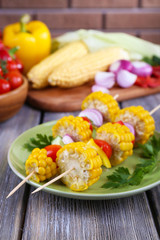 Sliced vegetables on wooden picks on plate on table close-up