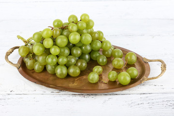 Green grape on tray on wooden background