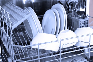 Open dishwasher with clean utensils in it