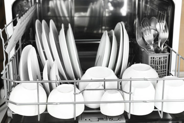 Open dishwasher with clean utensils in it
