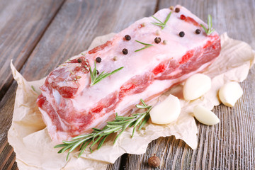 raw bacon with spices on wooden table