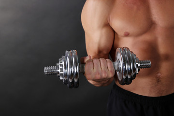 Fototapeta na wymiar Muscle young sportsman execute exercise with dumbbell