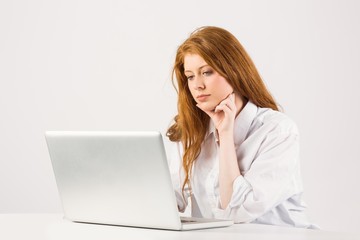 Pretty redhead working on laptop