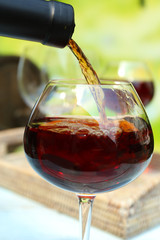 Red wine pouring into wine glass, close-up