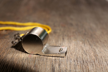 Sport metal whistle on wooden background