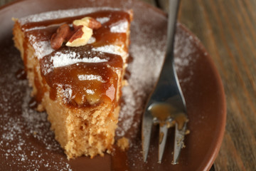 Half eaten delicious cake piece on plate on wooden table