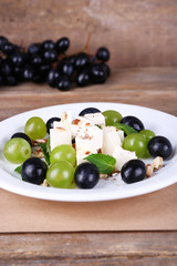 tasty salad with grape and cheese on wooden table