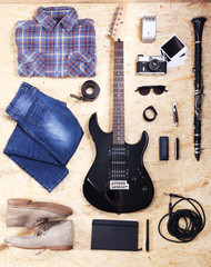 Naklejka premium Musical equipment, clothes and footwear on wooden background