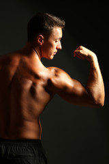 Obraz na płótnie Canvas Handsome muscle young man on dark background