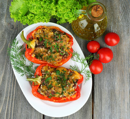 Stuffed red peppers with greens and vegetables on table close