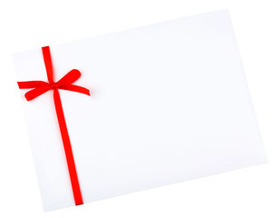 White envelope and red ribbon isolated on white