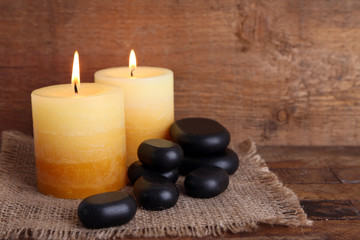 Obraz na płótnie Canvas Spa stones with candles on wooden background