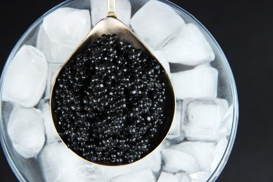 Black caviar in metal dish and ice in glass bowl