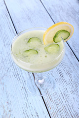 Cucumber cocktail with lemon on wooden background