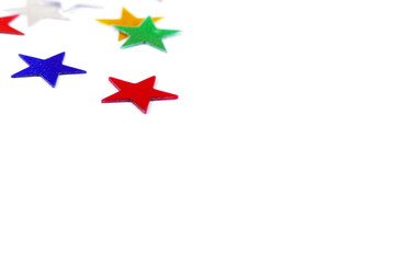 Christmas decoration of colored confetti stars against white bac